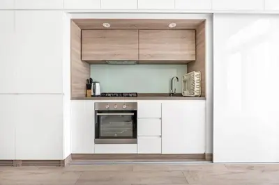 a kitchen with white cabinets and a stove at StoneTree - Studio One Tower Studio - Amazing View and Facilities in Dubai