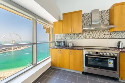 a kitchen with a view of the ocean at Ain Dubai & Sea Views 2BR Close to Beach, Rimal 4, Jumeirah Beach Residence, by Deluxe Holiday Homes in Dubai