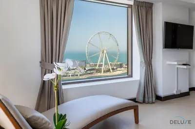a room with a large window with a ferris wheel at Ain Dubai & Sea Views 2BR Close to Beach, Rimal 4, Jumeirah Beach Residence, by Deluxe Holiday Homes in Dubai