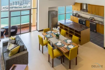 a kitchen and dining room with a table and yellow chairs at Ain Dubai & Sea Views 2BR Close to Beach, Rimal 4, Jumeirah Beach Residence, by Deluxe Holiday Homes in Dubai
