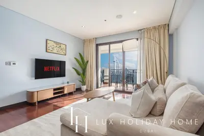 a living room with a couch and a tv at LUX The Anantara Residence Suite in Dubai