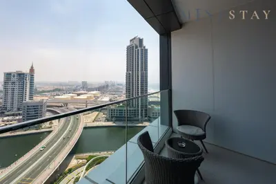 a balcony with two chairs and a view of a city at Address JBR Marina Views, Address Beach Resort Residence, Dubai Marina - Mint Stay in Dubai