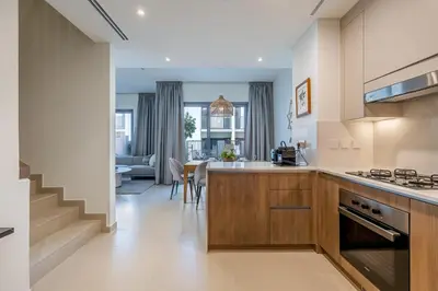 a kitchen with a counter and a dining room at Spacious 3BDR Townhouse I Garden I Tilal Al ghaf in Dubai