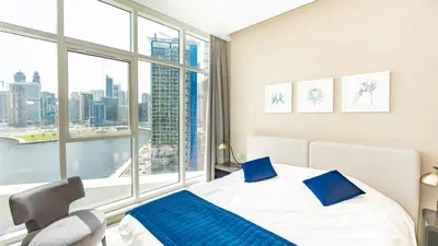a bedroom with a bed and a large window at Sleek Studio in Business Bay with Canal View Business Bay, Dubai in Dubai