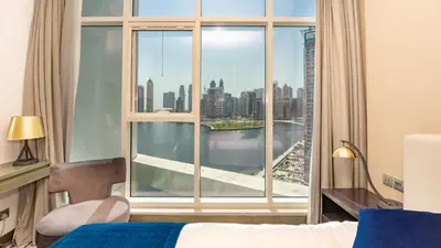 a bedroom with a large window with a view of the city at Sleek Studio in Business Bay with Canal View Business Bay, Dubai in Dubai