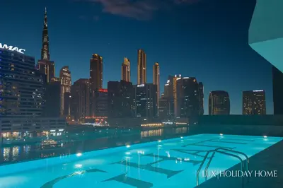 a view of a city skyline at night at LUX The Modern Binghatti Canal Suite in Dubai