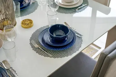 a table with a blue bowl and plates on it at Charming 2BR + kid's room w/ Marina yacht view in Dubai