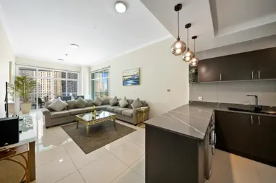a kitchen and living room with a couch and a table at Charming 2BR + kid's room w/ Marina yacht view in Dubai