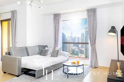 a living room with a couch and a large window at LUX The JBR Marina View Suite 2 in Dubai