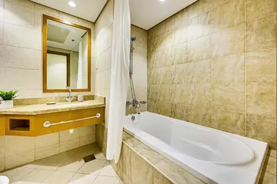 a bathroom with a tub and a sink and a mirror at Huge fantastic 3 bedroom in Al Fattan Marine Tower in Dubai