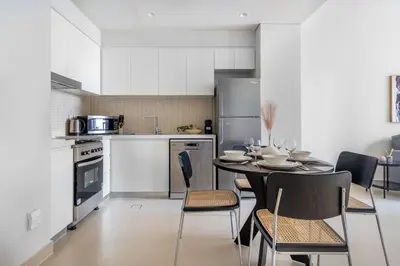 a kitchen and dining room with a table and chairs at GuestReady - A prime stay in Creek Harbour in Dubai