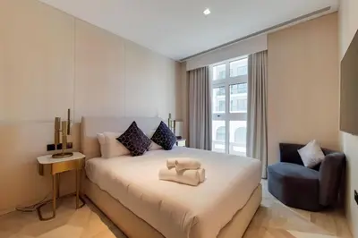 a bedroom with a large white bed and a chair at FIVE Palm North Residences - Spectacular Three Bedroom in Dubai