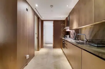 a kitchen with wooden cabinets and a sink and a hallway at FIVE Palm North Residences - Spectacular Three Bedroom in Dubai