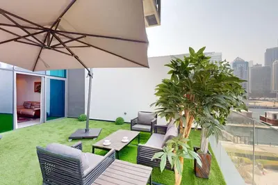 a rooftop patio with chairs and an umbrella at 15 Northside Tower 2 - Spacious One Bedroom in Dubai