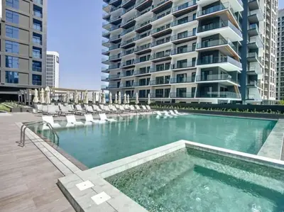 a swimming pool with chairs and a large building at 15 Northside Tower 2 - Charming One Bedroom in Dubai