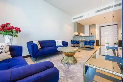a living room with blue couches and a table at 15 Northside Tower 2 - Charming One Bedroom in Dubai