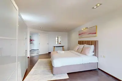 a bedroom with a white bed and a glass wall at Bahar 1 - Opulent Three Bedroom in Dubai
