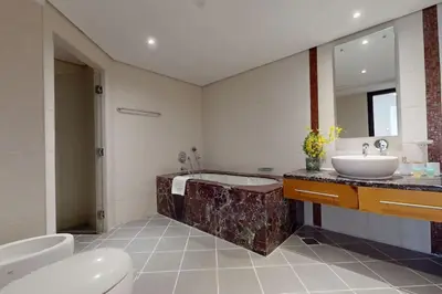 a bathroom with a tub and a sink and a toilet at Bahar 1 - Opulent Three Bedroom in Dubai