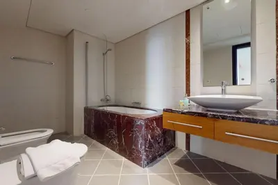a bathroom with a tub and a sink and a toilet at Bahar 1 - Opulent Three Bedroom in Dubai
