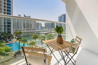a balcony with a table and chairs and a pool at Frank Porter - DAMAC Prive in Dubai