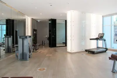 a large room with a gym with a treadmill and mirrors at Frank Porter - DAMAC Prive in Dubai