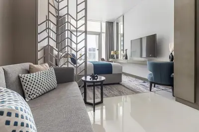 a living room with a couch and a bed and a tv at Frank Porter - DAMAC Prive in Dubai