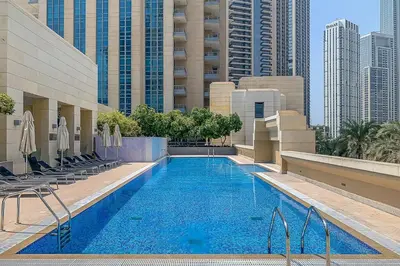 a swimming pool in a hotel with chairs and buildings at Frank Porter - Claren Tower in Dubai