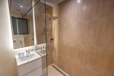 a bathroom with a shower with a sink and a mirror at Cozy Circle !Enjoyable Yet Affordable Studio Apartment! in Dubai