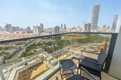 a balcony with two chairs and a view of a city at Cozy Circle !Enjoyable Yet Affordable Studio Apartment! in Dubai