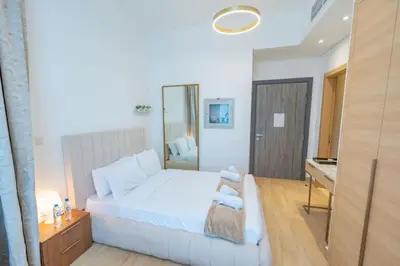 a bedroom with a large white bed and a desk at Cozy Circle !Enjoyable Yet Affordable Studio Apartment! in Dubai