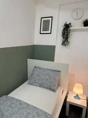 a bedroom with a bed and a clock on the wall at Beautiful Partition Room in Al barsha 1 Near Metro in Dubai