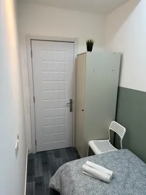 a room with a bed and a white door and a chair at Beautiful Partition Room in Al barsha 1 Near Metro in Dubai