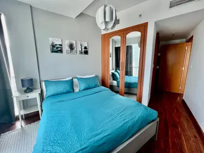 a bedroom with a blue bed and a mirror at The Waves 241 Dubai Marina in Dubai