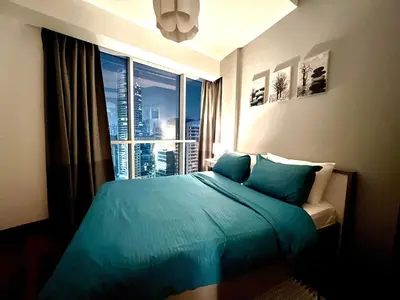 a bedroom with a blue bed and a large window at The Waves 241 Dubai Marina in Dubai