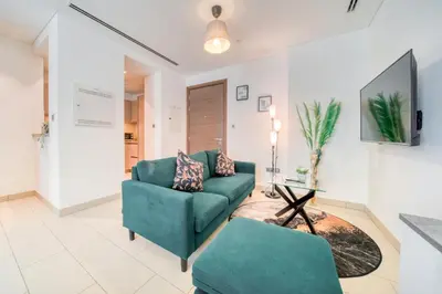 a living room with a couch and a table at Luxury Studio in Sobha Hartland Greens by PK Holidays in Dubai