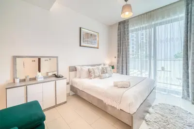 a bedroom with a large bed and a large window at Luxury Studio in Sobha Hartland Greens by PK Holidays in Dubai