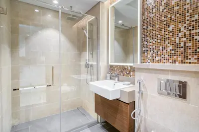 a bathroom with a sink and a glass shower at Luxury Studio in Sobha Hartland Greens by PK Holidays in Dubai