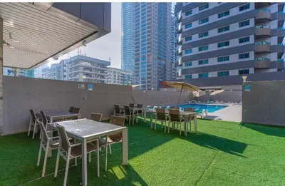 a rooftop patio with tables and chairs and a pool at SEASONING STAY AT DUBA MARINA in Dubai