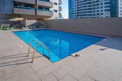 a large blue swimming pool on top of a building at SEASONING STAY AT DUBA MARINA in Dubai