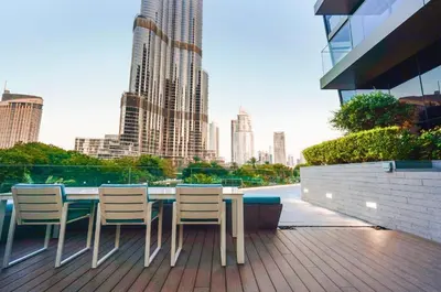 a table and chairs on a deck with a view of a city at Hotel Apartment Near Burj Khalifa - Opera T2 - شقة فندقية قريبة من برج خليفة اوبرا -برج 2 in Dubai