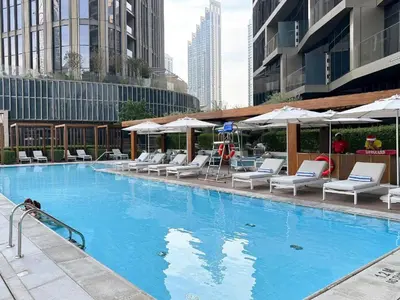 a large swimming pool with white chairs and umbrellas at Hotel Apartment Near Burj Khalifa - Opera T2 - شقة فندقية قريبة من برج خليفة اوبرا -برج 2 in Dubai