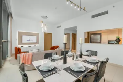 a dining room and living room with a table and chairs at Ultimate Stay Full Burj Khalifa & Downtown Views Designer Luxury High Floor connected to Dubai Mall for 4 People in Dubai