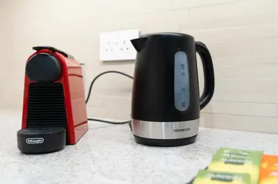 a black coffee maker and a toaster on a counter at Ultimate Stay Full Burj Khalifa & Downtown Views Designer Luxury High Floor connected to Dubai Mall for 4 People in Dubai