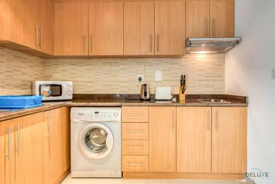 a kitchen with a washing machine and a microwave at Near to Iconic Miracle & Butterfly Garden Urban Vibe Studio, Lincoln Park A, Arjan-Dubailand by Deluxe Holiday Homes in Dubai