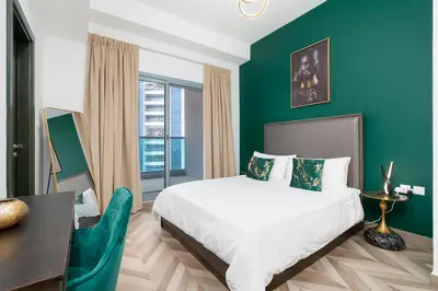 a bedroom with a large bed and a green wall at The Elite Apartment in Dubai