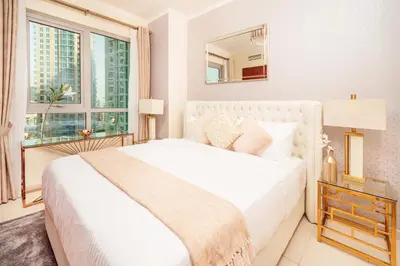 a white bedroom with a large bed and a window at Elite Royal Apartment - Full Burj Khalifa & Fountain View - Luxurious - Largest Layout - Melchior in Dubai