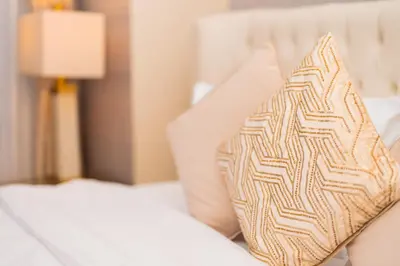 a pillow sitting on a bed next to a lamp at Elite Royal Apartment - Full Burj Khalifa & Fountain View - Luxurious - Largest Layout - Melchior in Dubai
