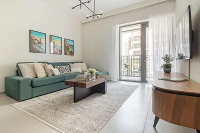 a living room with a green couch and a table at Frank Porter - Summer at Creek Beach in Dubai