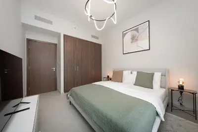 a bedroom with a large bed and a chandelier at Luxury apartments at Vida Residences in Dubai