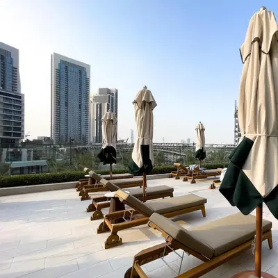 a row of lounge chairs and umbrellas on a roof at Luxury apartments at Vida Residences in Dubai